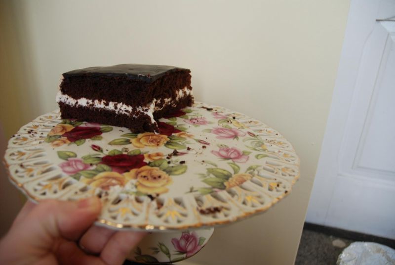 Brązowy torcik z białą masą i czekoladową polewą 