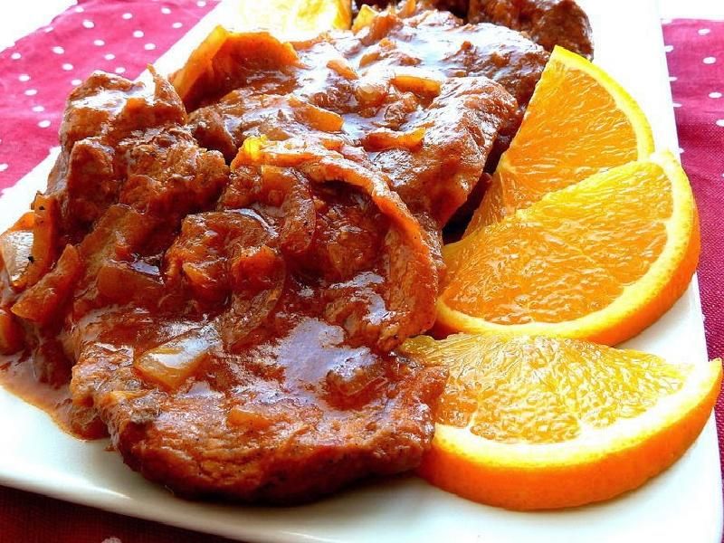 Czerwony schabowy z cebulą w pomarańczach