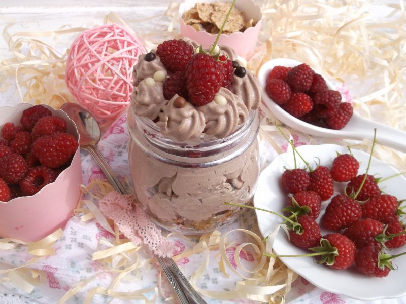 Deser z płatkami, bitą śmietaną i malinami