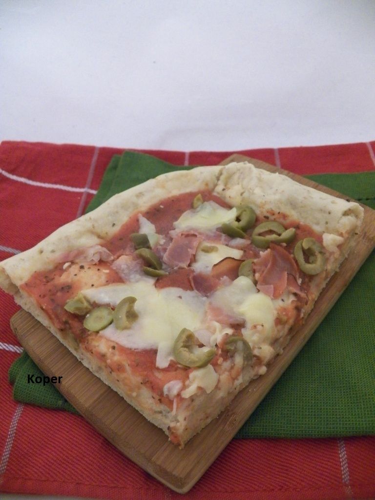 Pełnoziarnista pizza z serem szynką i oliwkami  Pełnoziarnista pizza z serem szynką i oliwkami