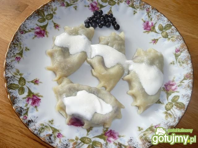 Pierożki z jagodami polane śmietaną