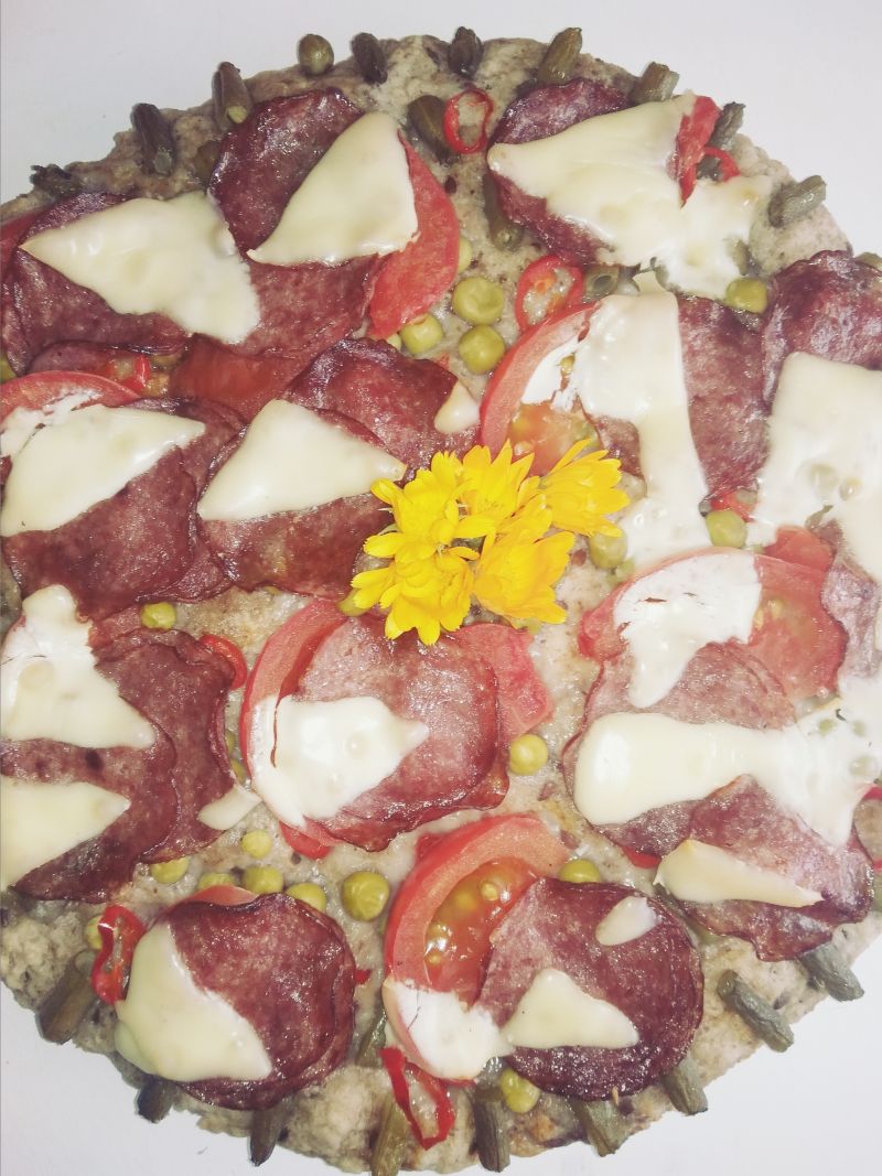 Pizza z fasolką szparagową, salami i serem.