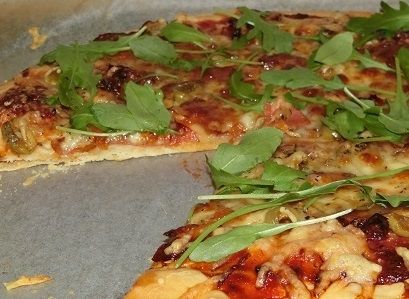 Pizza z mozzarellą, suszonymi pomidorami i rukolą