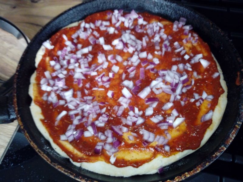 Pizza z patelni z białą kiełbasą i czerwoną cebulą