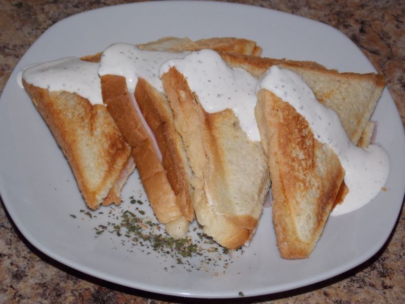 Sandwicze z szynką i serem polane sosem  Sandwicze z szynką i serem polane sosem