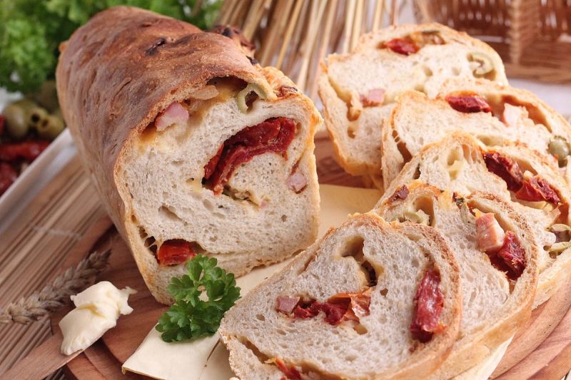 Serowy chleb z boczkiem oliwkami i pomidorami