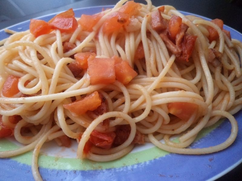Spaghetti z pomidorem i smażonym boczkiem .