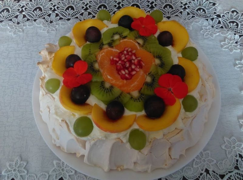 Tort bezowy z sosem z mango, kremem i owocami