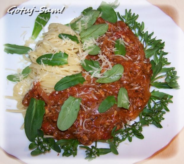 Spaghetti w stylu bolońskim z kwiatem roszponki.
